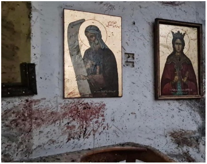 Paret de l'església on es veuen icones de sang que està esquitxada per la sang de les víctimes de l'atemptat.