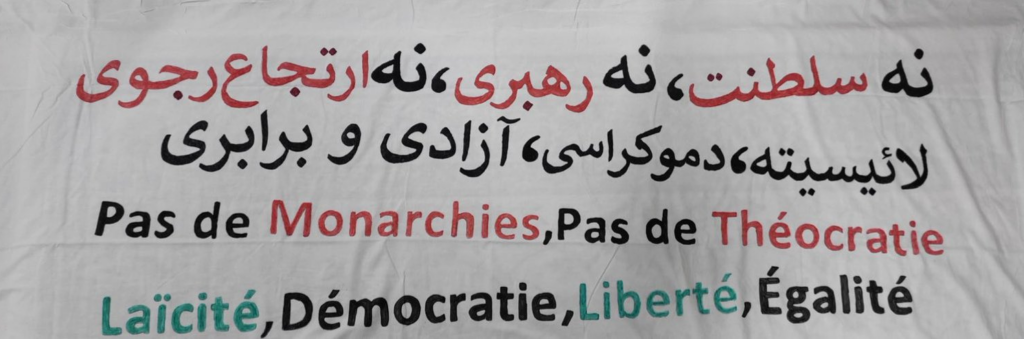 Pancarta en persa i francès que diu: Sense monarquies, sense teocràcia, secularisme, democràcia, llibertat, igualtat
